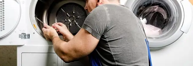 Dryer repair technician fixing a clothes dryer drum in Fort Collins, CO