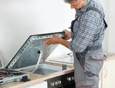 Appliance repair technician installing a built-in cooktop in Fort Collins, CO