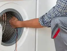 Dryer repair technician diagnosing and servicing a clothes dryer in Fort Collins, CO
