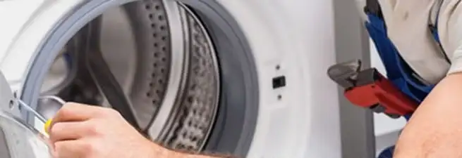 Appliance technician repairing a clothes dryer drum and internal parts in Fort Collins, CO
