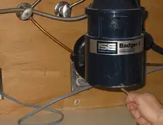 Garbage disposal repair technician tightening the mounting ring under a sink in Fort Collins, CO