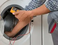 Washing machine repair technician testing a front-load washer with diagnostic tools in Fort Collins, CO