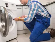 Washing machine repair technician servicing a front-load washer in Fort Collins, CO
