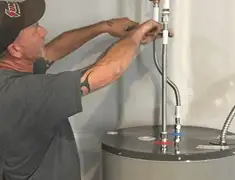 Water heater repair technician tightening supply line connections in Fort Collins, CO